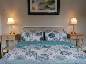 a bed with blue and white sheets and two lamps at Stunning 3 Bedroom townhouse in the heart of city in Belfast