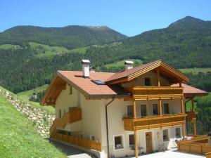 a house on a hill with mountains in the background at Ausserangistlhof in Campo Tures