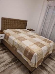 a bedroom with a bed with a quilt on it at Fush Kosov Apartment Center in Kosovo Polje