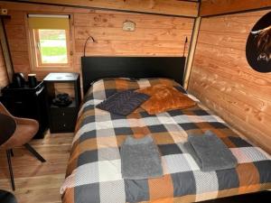 een slaapkamer met een bed in een houten hut bij Hoogte Huisje Schotland in Swalmen