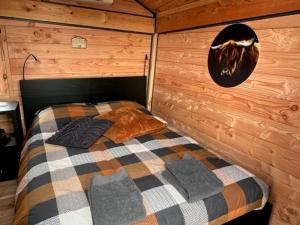 Hoogte Huisje Schotland في Swalmen: غرفة نوم بسرير في كابينة خشبية