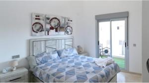 a bedroom with a blue and white bed with a window at Sun-Golf-Beach Villamartin in Alicante +11 photos