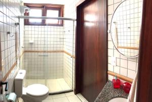 a bathroom with a toilet and a glass shower at Casa em condomínio, beira mar e piscina Barra de São Miguel - Maceió- AL in Barra de São Miguel
