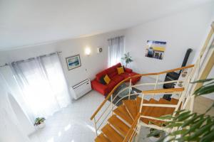 a living room with a staircase and a red couch at Villa Sanda with Private Pool in Zadar