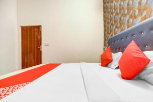 1 dormitorio con 1 cama con almohadas rojas y blancas en Flagship Hotel 3k Inn, en Ludhiana