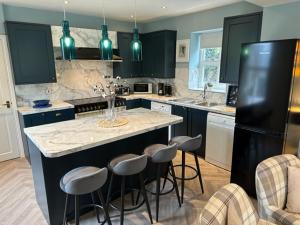a kitchen with a large island with bar stools at Bagshaw Mews in Bakewell