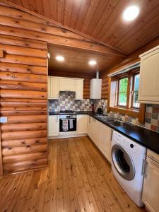 a kitchen with a washer and dryer in a log cabin at Countryside 3 Bedroom Log Cabin With Private Hot Tub - Ash in Leominster