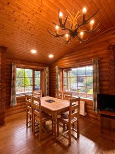 a dining room with a wooden table and chairs at Countryside 3 Bedroom Log Cabin With Private Hot Tub - Ash in Leominster