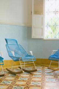 Tres sillas azules en una habitación con alfombra en Casa Colonial en Manga en Cartagena de Indias