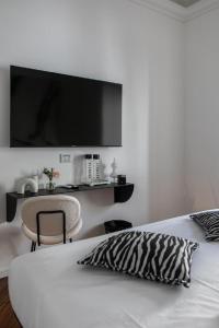 Schlafzimmer mit einem Bett und einem TV an der Wand in der Unterkunft Bhr Cavour 150 in Rom