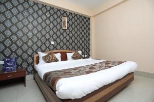 een slaapkamer met een bed en een muur bij Collection O Hotel Greenpark in Jamshedpur