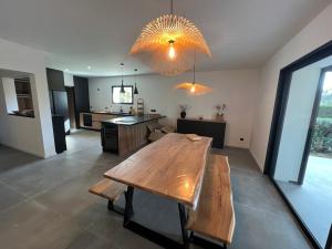 a dining room and kitchen with a wooden table at Villa bord de mer piscine, jacuzzi in Hyères