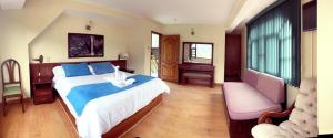 Hotel Donde Marcelo في بانوس: غرفة نوم بسرير كبير وأريكة