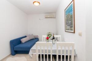 a living room with a blue couch and a table at Apartments Savić in Herceg-Novi