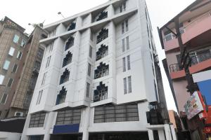 a white building with windows on a street at Super Collection O Hotel President in Guwahati