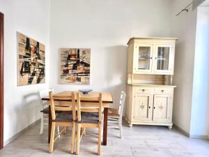 ein Esszimmer mit einem Holztisch und Stühlen in der Unterkunft Bilocale Nel Centro Storico - Prossimo al Mare in Pachino