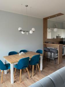 a dining room with a wooden table and blue chairs at Marchewkowy in Siemiany