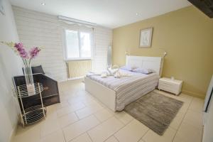 een slaapkamer met een bed en een vaas met bloemen bij Villa de vacances moderne à côté de Bergerac in Prigonrieux +33 foto's