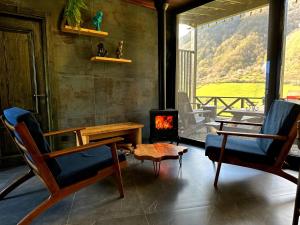 a living room with two chairs and a wood stove at Runaway House - Qalacıq in Gabala