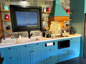 a kitchen with a sink and a microwave at Runaway House - Qalacıq in Gabala