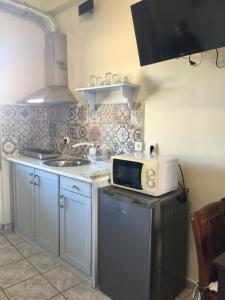 a kitchen with a microwave on top of a refrigerator at happyWish Syros in Ermoupoli