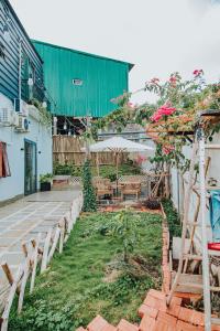 einen Garten mit Bänken und Tischen und ein Gebäude in der Unterkunft Laca homestay in Gia Nghĩa