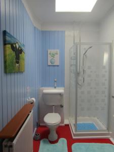 a bathroom with a toilet and a shower with a cow painting at Athollbank Guest House in Dundee