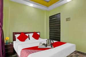 Habitación de hotel con cama con almohadas rojas en Om Sai Ram Residency, en Bombay