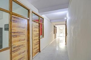 um corredor com portas de madeira numa casa em Capital O Diamond 18 Near Worlds Of Wonder em Kālkāji Devi