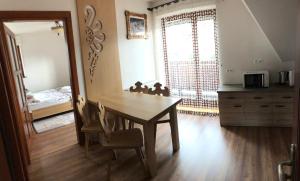 a dining room with a table and a bedroom at Apartamenty u Ani in Ząb