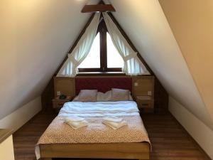 a bedroom with a bed in a attic with a window at Apartamenty u Ani in Ząb