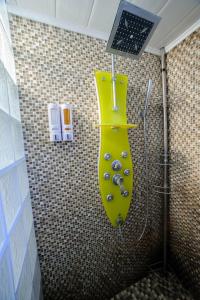 a bathroom with a shower with a yellow sink at Villa de vacances moderne à côté de Bergerac in Prigonrieux