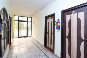 a hallway with two doors and a fire extinguisher at Flagship Hotel Sweet Night in Ghaziabad