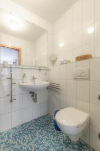 a white bathroom with a toilet and a sink at Ferienwohnung Roter Kater am Nationalpark Eifel in Bergbuir