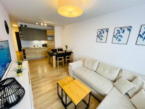 un salon avec un canapé blanc et une table dans l'établissement Sun4You Polanki Park, à Kołobrzeg