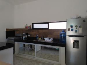 a kitchen with a counter and a refrigerator at Casa Flamingo Telchac in Telchac Puerto