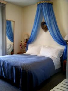 a bedroom with a bed with a blue canopy at Hotel Post in Bergamo