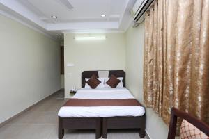 1 dormitorio con cama y cortina en Hotel Saraswathi Residency Near SR Nagar Metro Station, en Ameerpet
