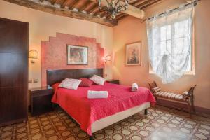 a bedroom with a red bed with a red blanket at Antica Residenza Santa Chiara -City Center in Lucca