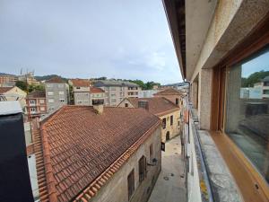 een uitzicht op de stad vanuit het raam van een gebouw bij Ático48 in Redondela
