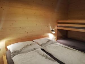 a bed in a room with a wooden wall at Ferienhaus-Eisenerz in Eisenerz