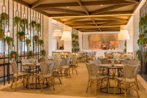 a restaurant with tables and chairs in a room at Ilunion Islantilla in Islantilla