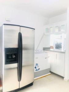 a stainless steel refrigerator with a microwave in a kitchen at Casa en Baní cerca de la playa in Baní