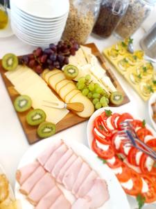 a table topped with cheese and meats and grapes at Krupówka Resort Boutique Hotel Szczyrk - Baseny, SPA, Wellness, Restauracja z widokiem in Szczyrk