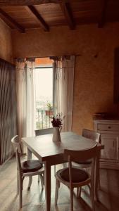 tavolo e sedie in una stanza con finestra di Casa Vacanze Le Tre Casette ad Ameglia