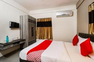 1 dormitorio con 1 cama grande con almohadas rojas en OYO Kuber Residency Near Birla Mandir, en Calcuta