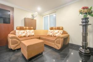 sala de estar con 2 sillas y sofá en Pride Hospitality Nungambakkam, en Chennai
