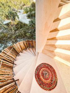 a spiral staircase with a hat on the floor at Casa Noma-Noma Holbox in Holbox Island