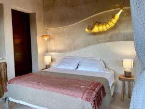 a bedroom with a bed and two tables with lamps at Casa Noma-Noma Holbox in Holbox Island