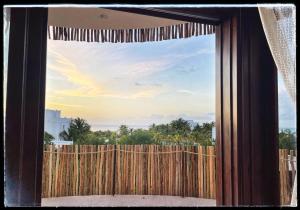 a window with a view of a wooden fence at Casa Noma-Noma Holbox in Holbox Island